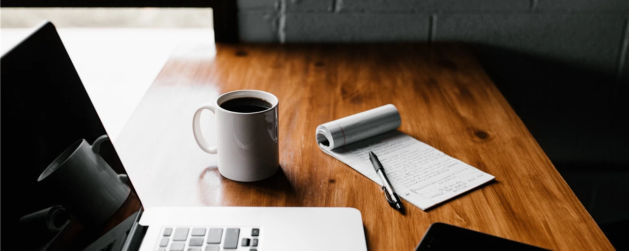 Coffee and Laptop on Wooden Desk