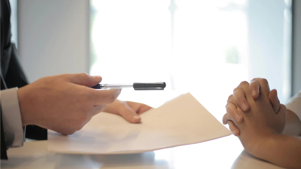 Crop businessman giving contract to woman to sign