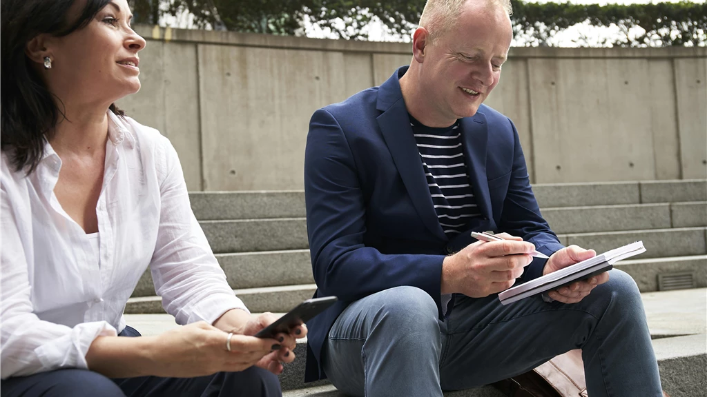 Woman and Man Having a Discussion While Sitting on Steps